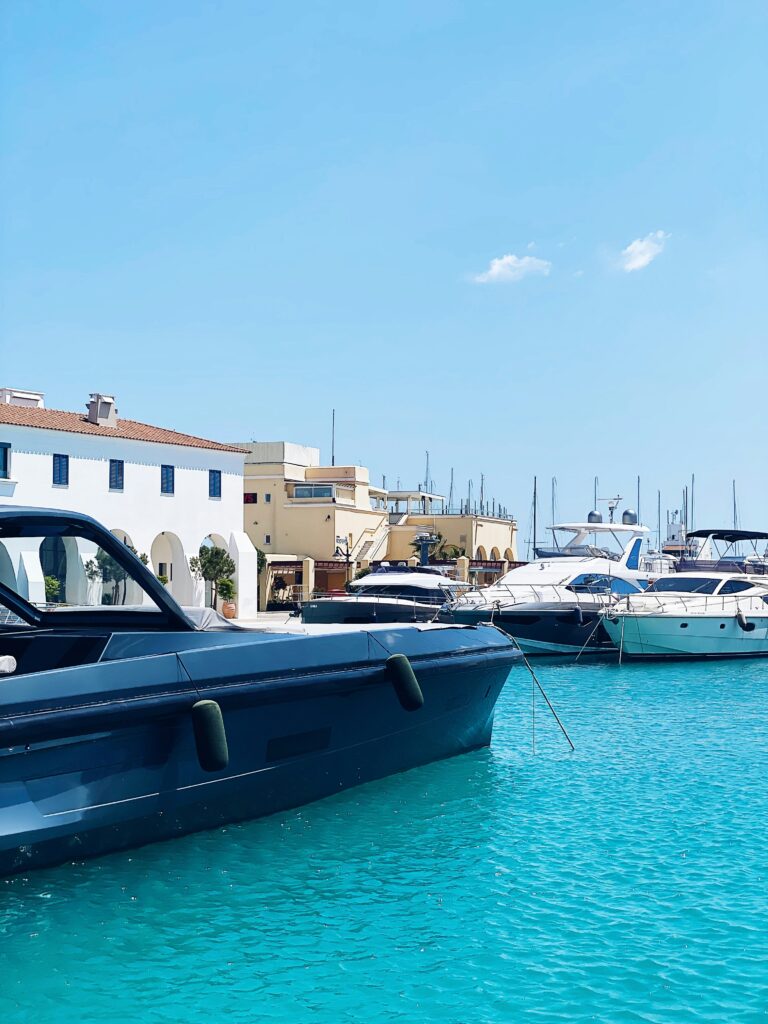 a blue boat in the water next to a white building