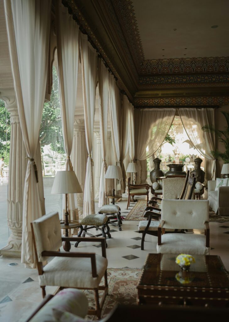 a room with a table chairs and a chandelier a room with a table chairs and a chandelier
