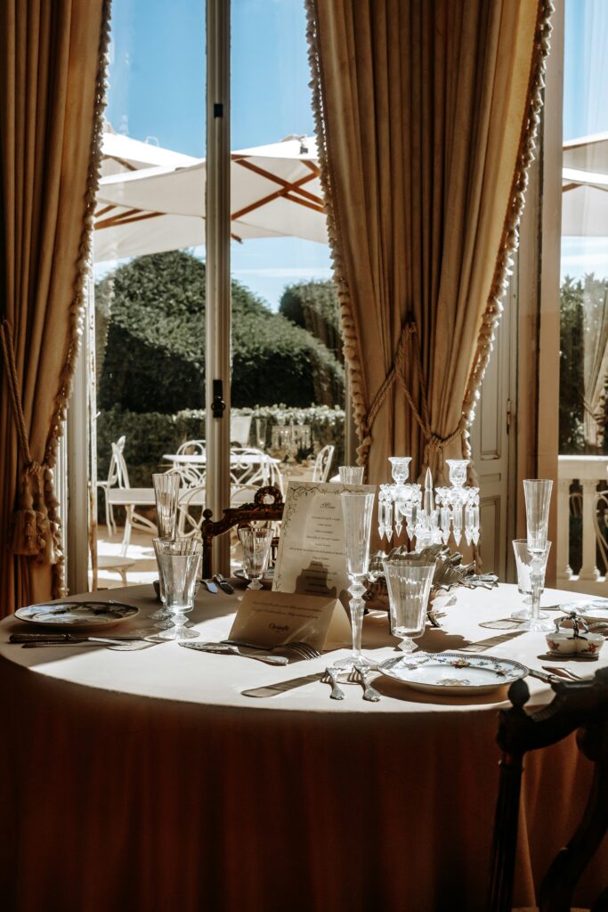 a table set for a formal dinner with a view of the outdoors